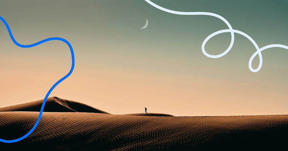 A lone figure walking across sand dunes at dusk.